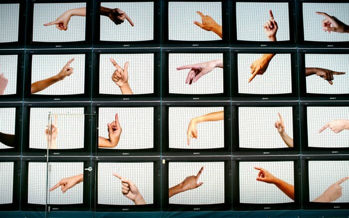 A conceptual image with a grid of different photos of hands, each pointing in different directions
