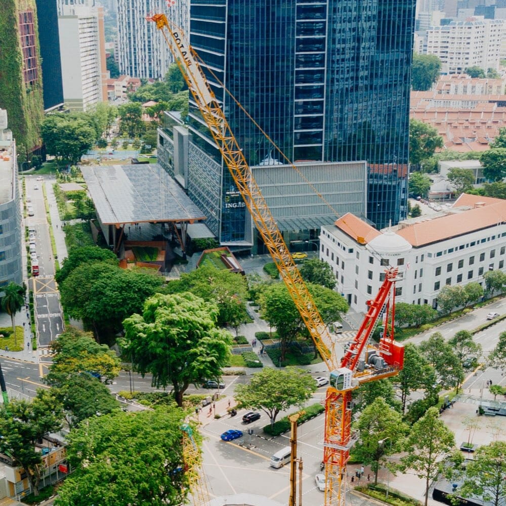orange crane in an urban environment of buildings and trees